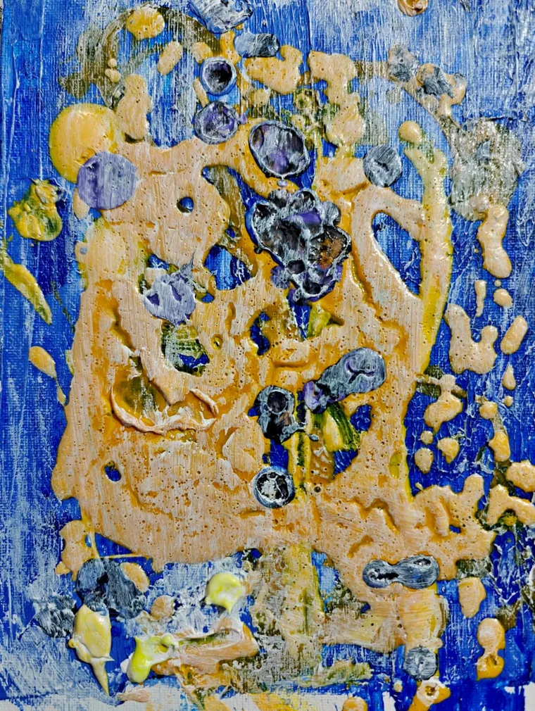 A heavily textured impasto painting: a mass of ochre and sand-coloured paint studded with blue-grey nodules on a deep cobalt-blue ground, like a reef or atoll seen from above.