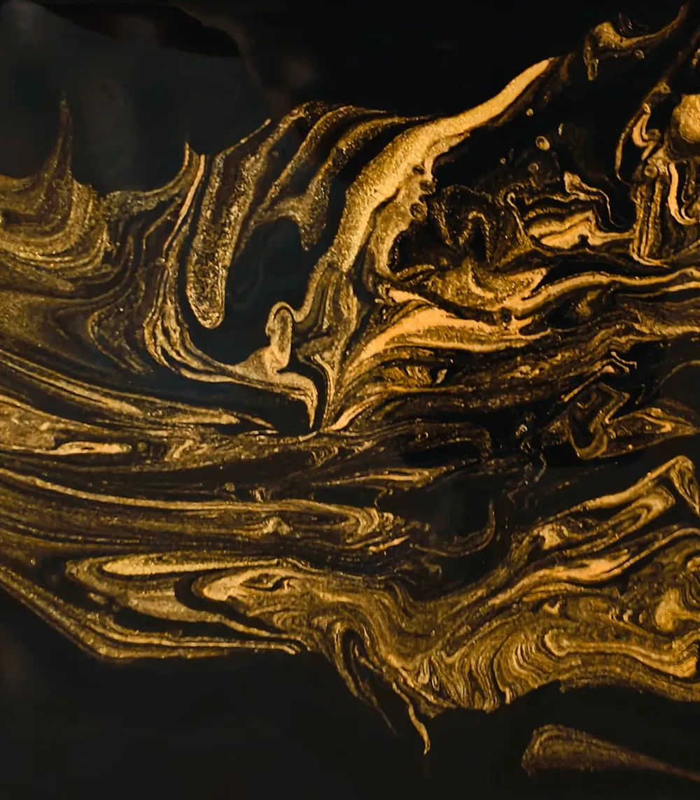 Swirling veins of metallic gold and bronze marbled across a deep black ground, like gold dust adrift in the void.
